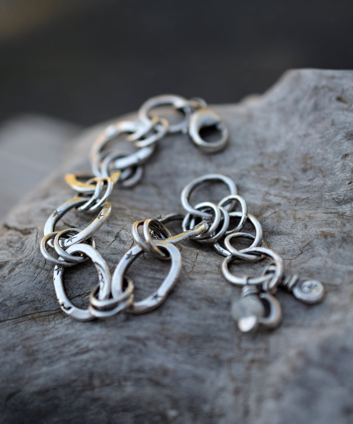 Silver Chain Bracelet sitting on a piece of wood. 