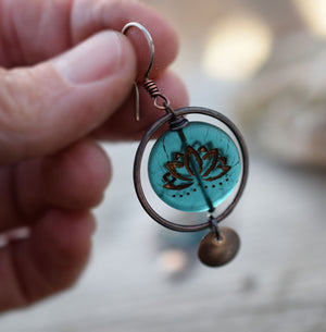 Copper hoop earrings with blue glass lotus beads at the center with golden highlights. Brass circle dangles. Bohemian Style Earrings that are handmade.