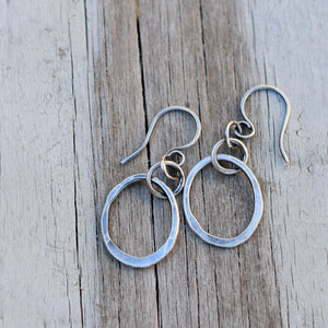 Silver hoop earrings on a wood background