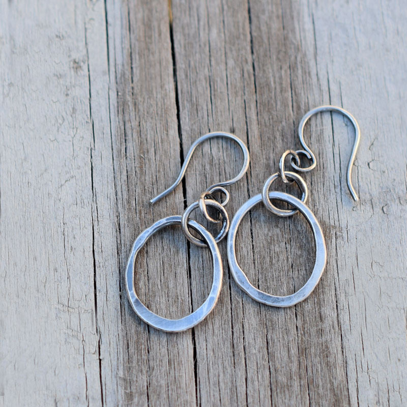 Silver hoop earrings on a wood background